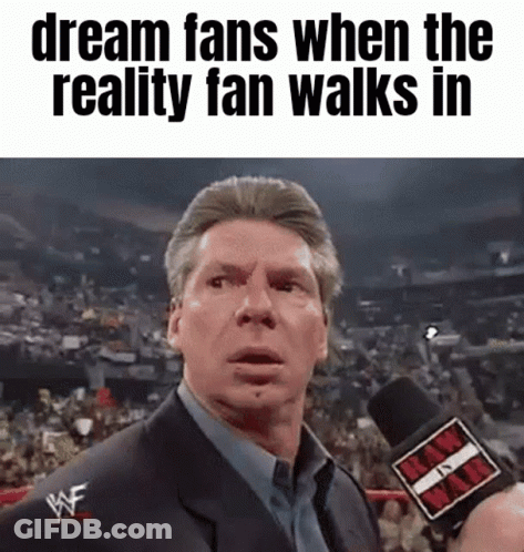 A Man In A Suit Is Talking Into A Microphone With The Words Dream Fans When The Reality Fan Walks In Below Him GIF