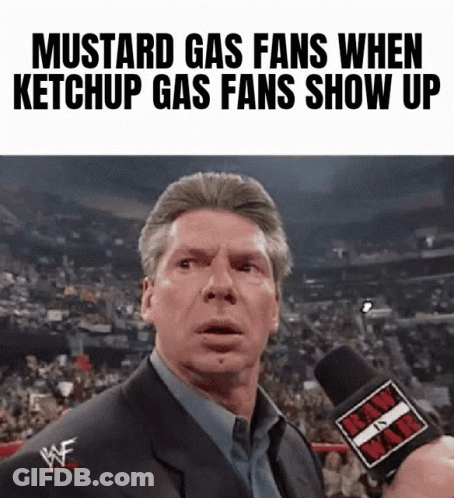 A Man In A Suit Is Talking Into A Microphone With The Words Mustard Gas Fans When Ketchup Gas Fans Show Up On The Bottom GIF