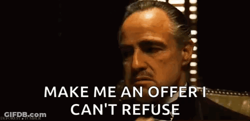 A Man In A Suit Is Talking On A Cell Phone And Saying Make Me An Offer I Can 'T Refuse . GIF