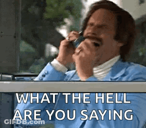 A Man In A Suit Is Talking On A Cell Phone . GIF