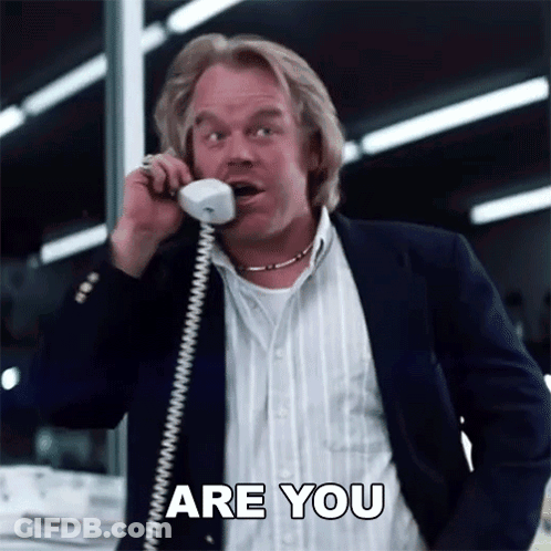 A Man In A Suit Is Talking On A Phone And Says Are You GIF