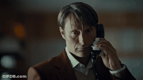 A Man In A Suit Is Talking On A Phone And Wiping His Face With A Napkin GIF