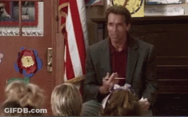 A Man In A Suit Is Talking To A Group Of Children In Front Of An American Flag . GIF