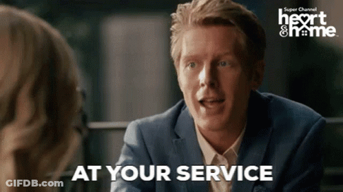 A Man In A Suit Is Talking To A Woman And Says " At Your Service " . GIF