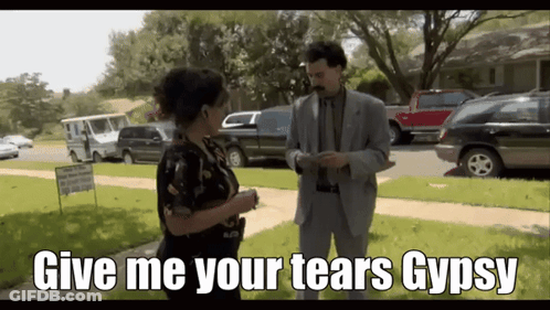 A Man In A Suit Is Talking To A Woman With The Words Give Me Your Tears Gypsy On The Bottom GIF