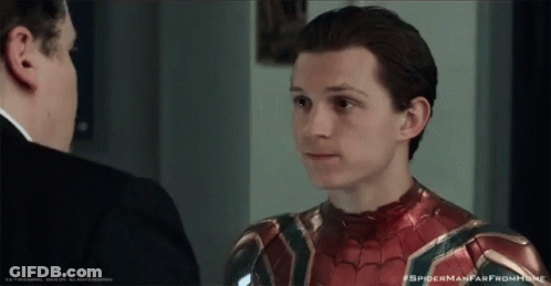 A Man In A Suit Is Talking To Another Man In A Spider Man Suit GIF