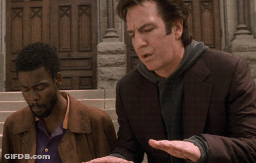 A Man In A Suit Is Talking To Another Man In Front Of A Building GIF
