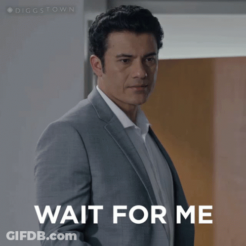 A Man In A Suit Is Waiting For Someone To Wait For Him GIF
