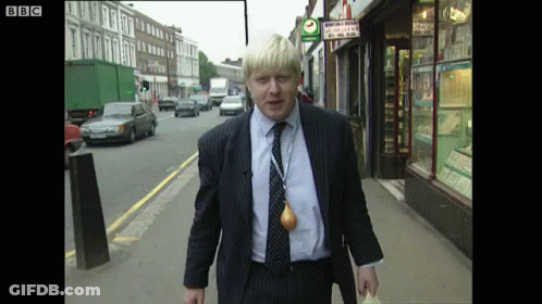 A Man In A Suit Is Walking Down A Street With A Bbc Logo On The Bottom Right GIF