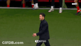 A Man In A Suit Is Walking On A Soccer Field With A X On It GIF