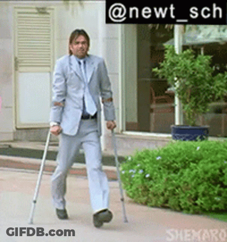 A Man In A Suit Is Walking With Crutches In Front Of A Building GIF