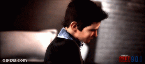 A Man In A Suit Looks Down With The Words Reed900 Behind Him GIF