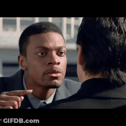 A Man In A Suit Points At Another Man In A Black Suit GIF
