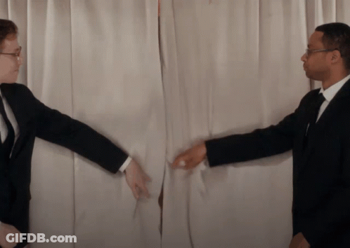A Man In A Suit Reaches Out To Another Man In A Suit GIF