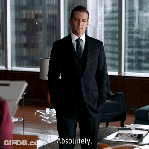 A Man In A Suit Says Absolutely In Front Of A Window GIF