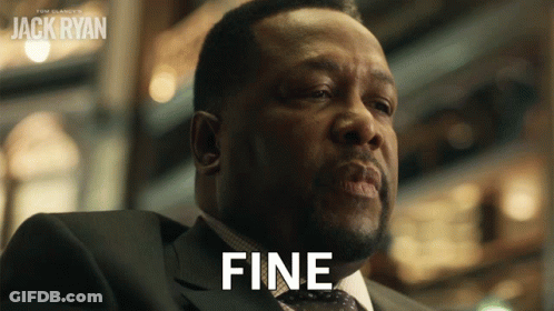 A Man In A Suit Says Fine In Front Of A Poster For Jack Ryan GIF