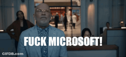 A Man In A Suit Says Fuck Microsoft In Front Of A Crowd GIF