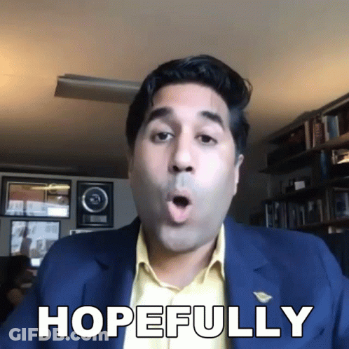 A Man In A Suit Says Hopefully In Front Of A Bookshelf GIF