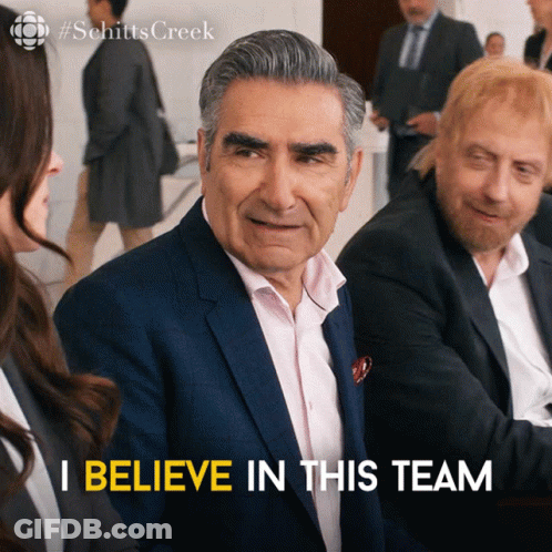 A Man In A Suit Says " I Believe In This Team " In Front Of A Group Of People GIF
