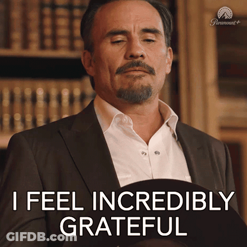 A Man In A Suit Says " I Feel Incredibly Grateful " While Holding A Hat GIF