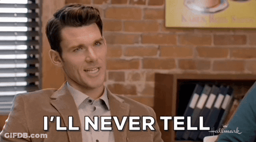 A Man In A Suit Says " I 'Ll Never Tell " In Front Of A Brick Wall GIF
