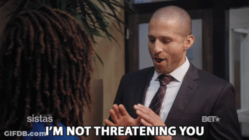 A Man In A Suit Says I 'M Not Threatening You To A Woman GIF