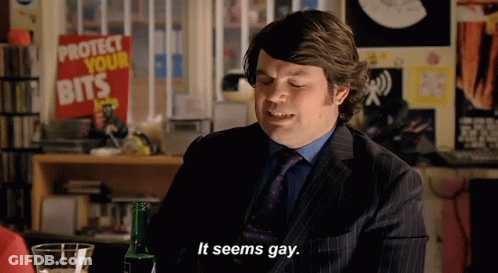 A Man In A Suit Says It Seems Gay In Front Of A Sign That Says Protect Your Bits GIF