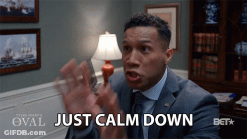 A Man In A Suit Says Just Calm Down In Front Of A Lamp GIF
