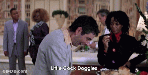A Man In A Suit Says Little Cock Doggies In Front Of A Group Of People . GIF