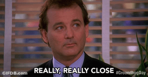 A Man In A Suit Says Really Really Close In Front Of A Window GIF