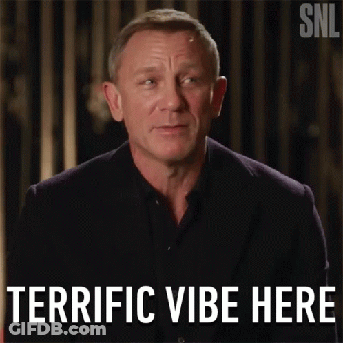 A Man In A Suit Says Terrific Vibe Here In Front Of A Snl Logo GIF