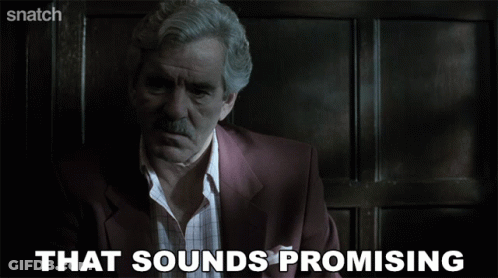 A Man In A Suit Says That Sounds Promising On A Screen GIF