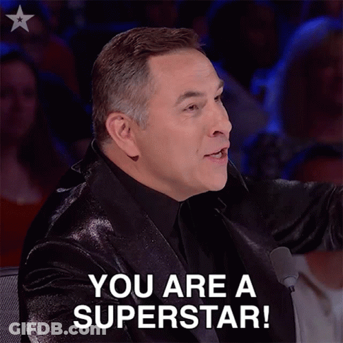 A Man In A Suit Says " You Are A Superstar " In Front Of A Microphone GIF