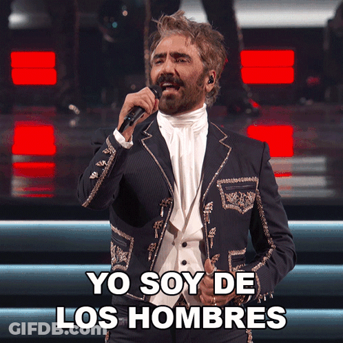 A Man In A Suit Singing Into A Microphone With Yo Soy De Los Hombres Below Him GIF