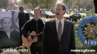 A Man In A Suit Sings While Another Man Plays Guitar GIF