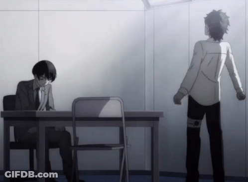 A Man In A Suit Sits At A Desk While Another Man Stands In Front Of Him GIF