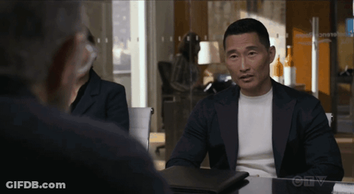 A Man In A Suit Sits At A Table In Front Of A Sign That Says " Ctv " On It GIF