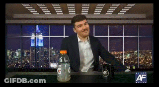 A Man In A Suit Sits At A Table With A Bottle Of Gatorade GIF