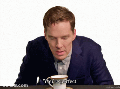 A Man In A Suit Sits At A Table With A Cup Of Coffee And The Words You 'Re Perfect Above Him GIF