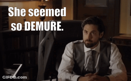 A Man In A Suit Sits In A Chair With The Words She Seemed So Demure Above Him GIF