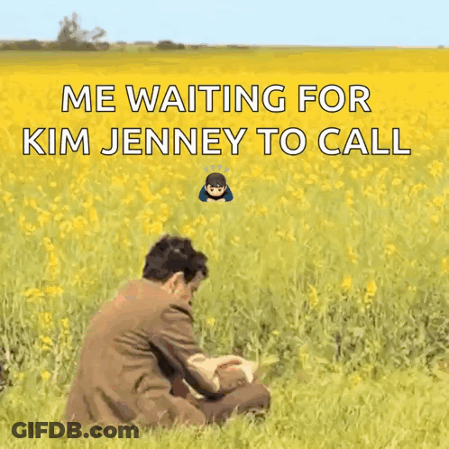 A Man In A Suit Sits In A Field Of Yellow Flowers Waiting For Kim Jenney To Call Him GIF