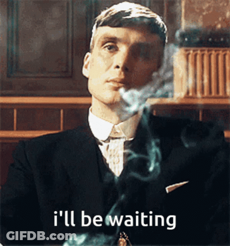 A Man In A Suit Smoking A Cigarette With The Words I 'Ll Be Waiting Behind Him GIF
