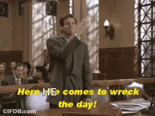 A Man In A Suit Stands In A Courtroom With The Words Here He Comes To Wreck The Day GIF