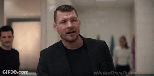 Man In Suit Standing In Hallway With Never Backdown Revolt Text GIF