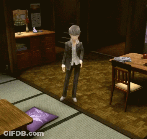 A Man In A Suit Stands In A Living Room With A Purple Pillow On The Floor GIF