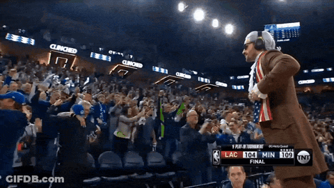 A Man In A Suit Stands In Front Of A Crowd At A Basketball Game With The Score Lac 104 Min 109 GIF