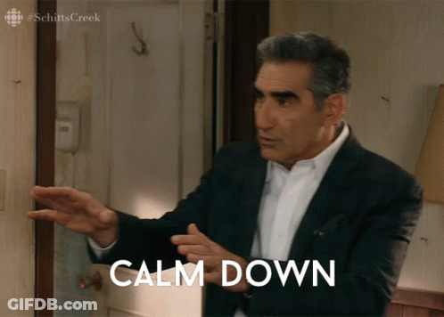 A Man In A Suit Stands In Front Of A Door With Calm Down Written On It GIF