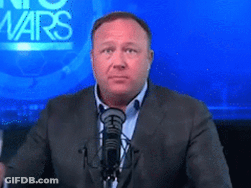 A Man In A Suit Stands In Front Of A Microphone In Front Of A Screen That Says No Wars GIF