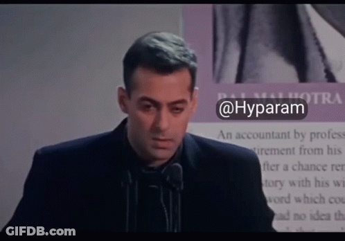 A Man In A Suit Stands In Front Of A Microphone With The Hashtag @Hyparam GIF