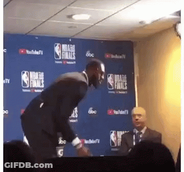 A Man In A Suit Stands In Front Of A Nba Finals Sign GIF